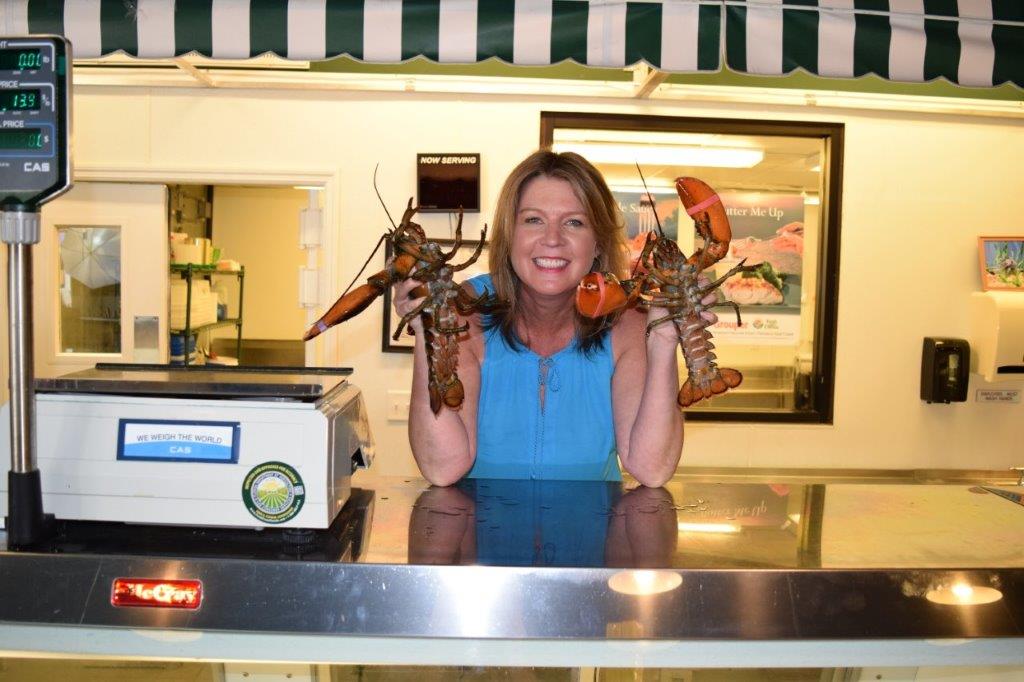 Josee in fish market holding lobsters